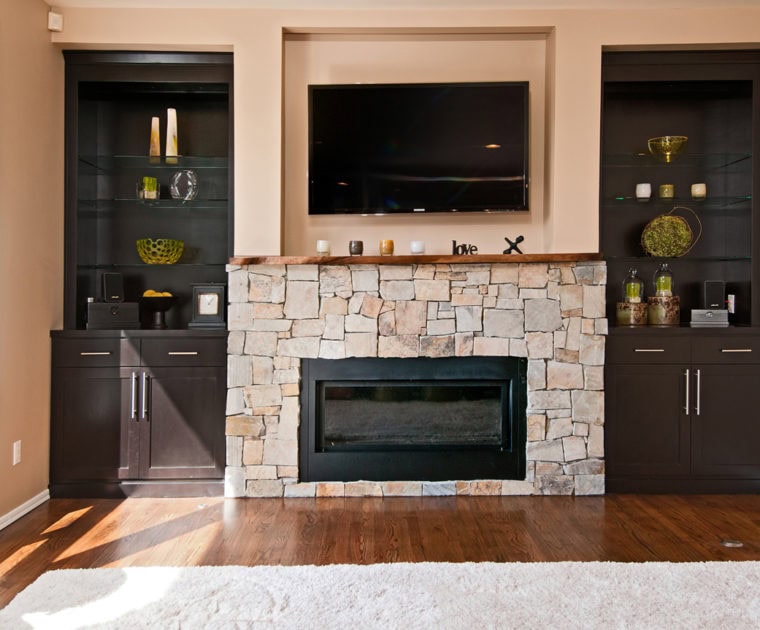 television mounted stone fireplace brown cabinets